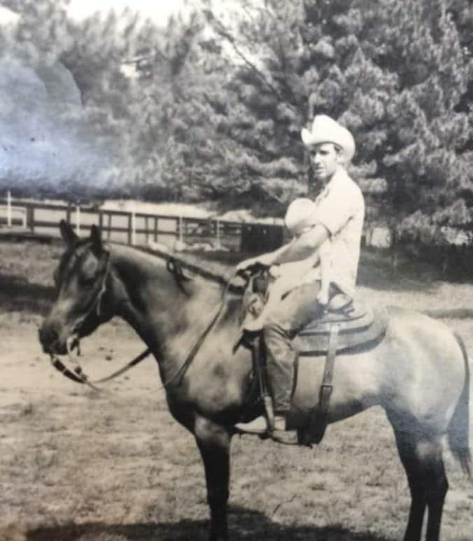 Rufus Hayes on horseback holding a baby